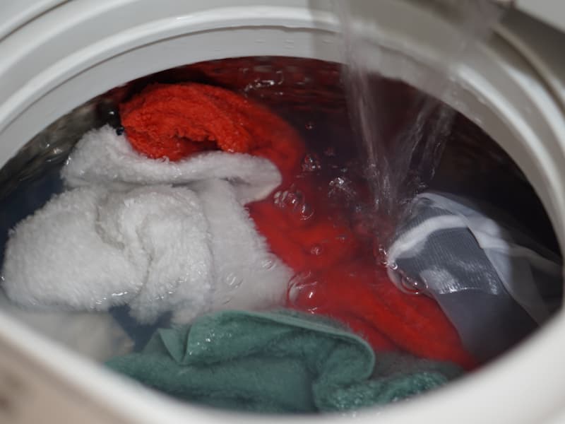 洗濯機でたっぷりの水でタオルを洗う様子（注水中）