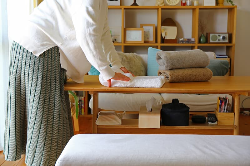 テーブルの上でバスタオルを畳んでいるシーン